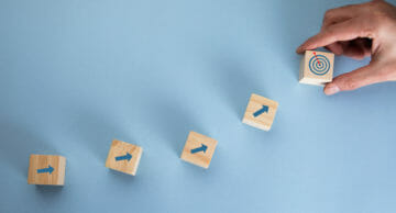 Young,Business,Man,Holding,Cubes,And,Target